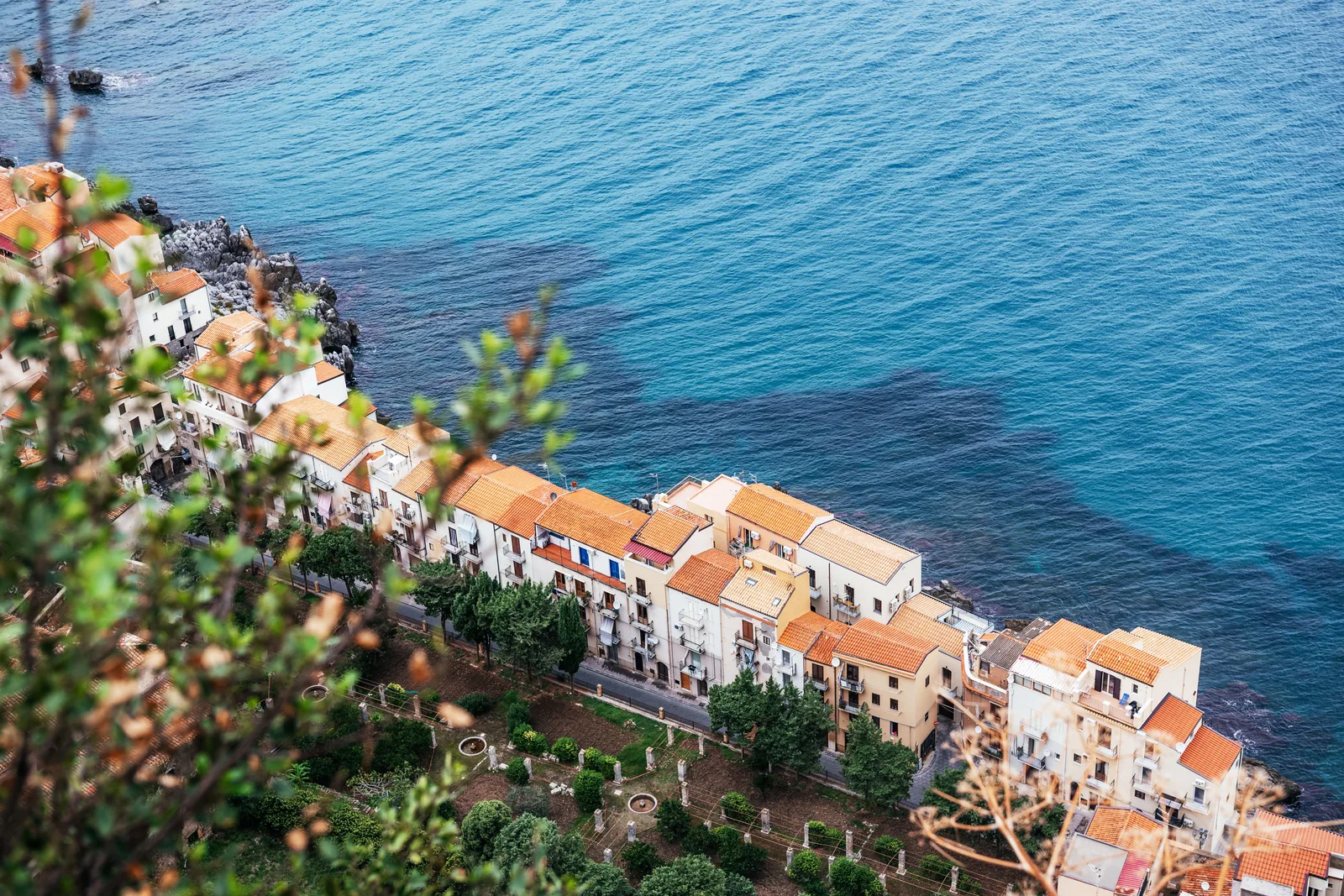 Terracotta rooftops of Cefalù above deep blue open water