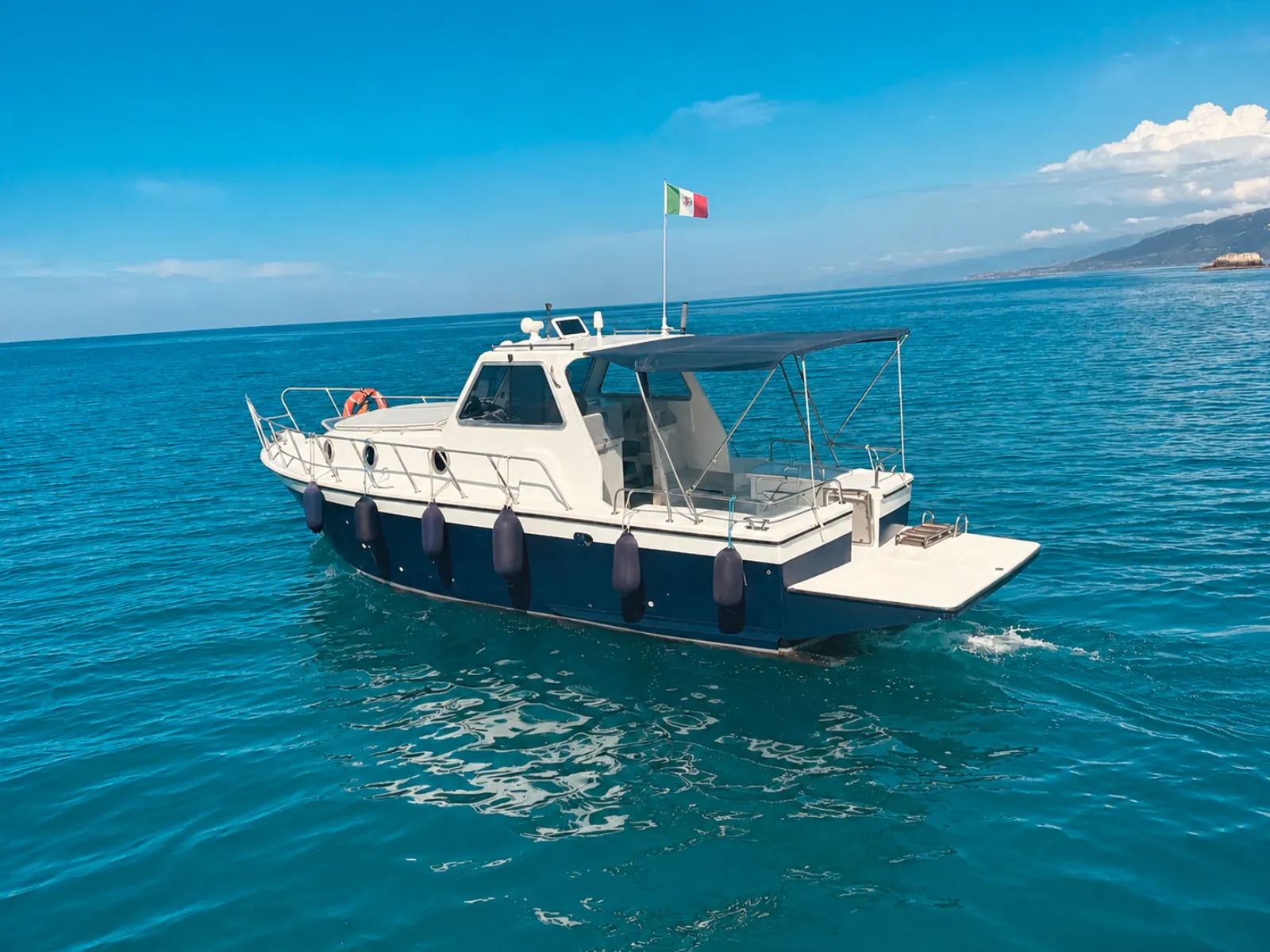 The boat under way along the coast, Italian flag at the stern