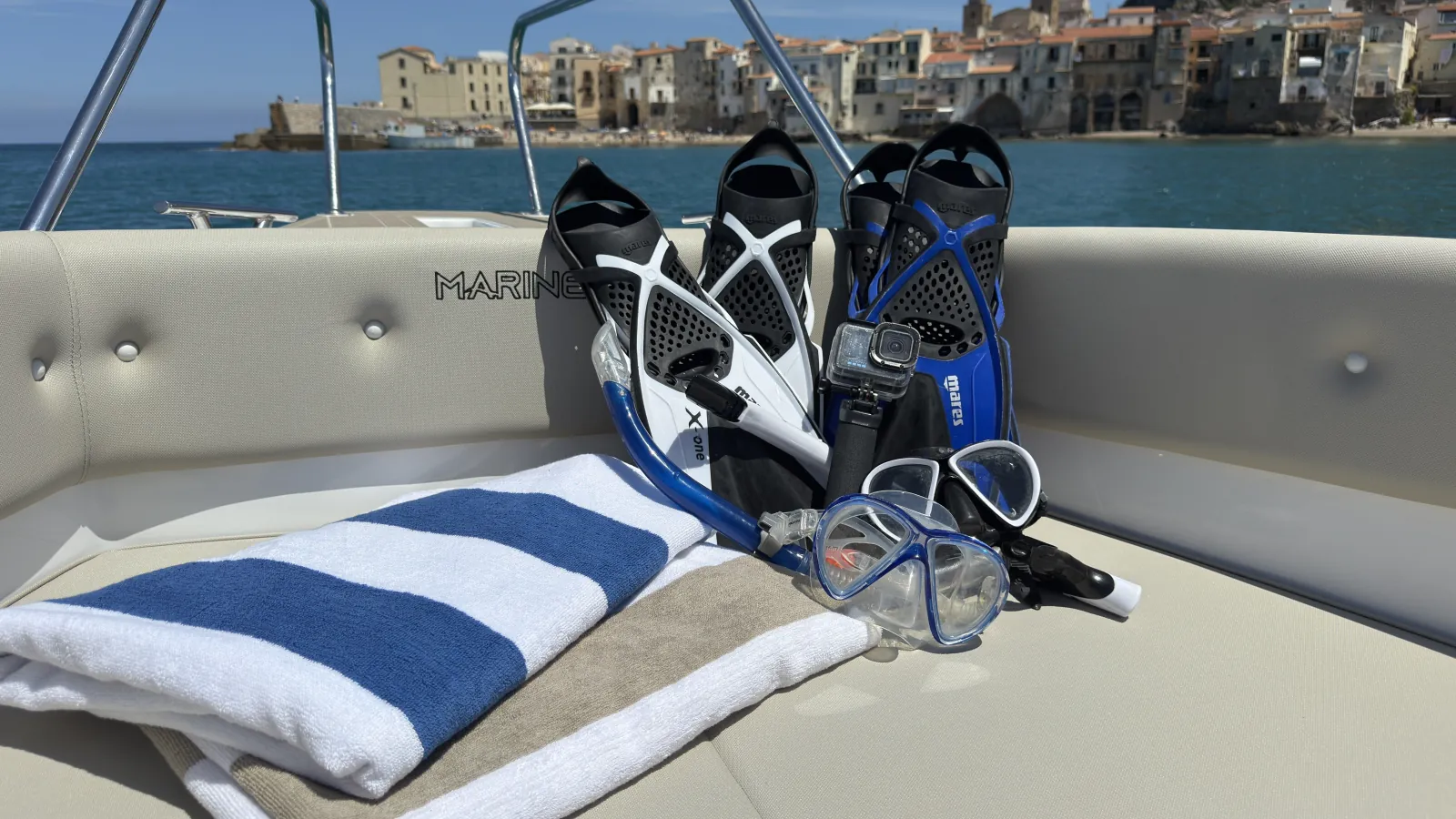 Folded towels, masks and fins laid out on the boat's cushions before departure